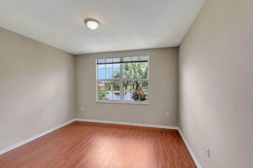 15155 Michelangelo Boulevard, Unit 306 Delray Beach, FL 33446 - Photo 19 of 32 an empty room with wooden floor and windows