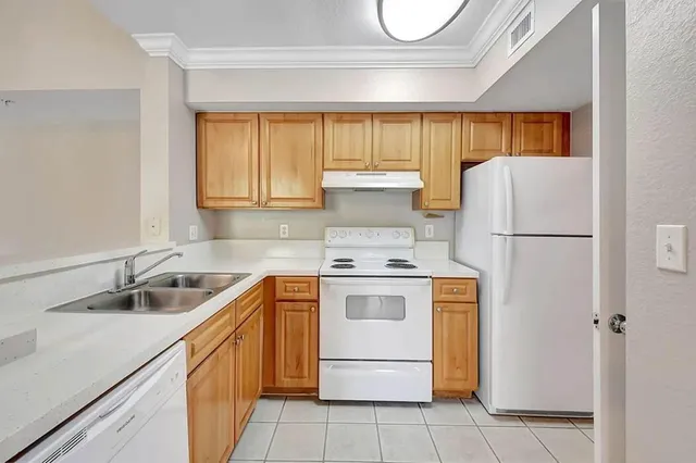 a kitchen with a stove sink and cabinets
