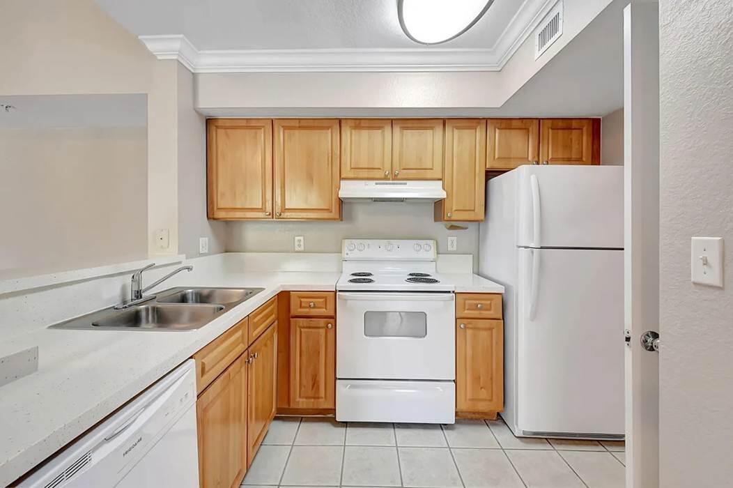 15155 Michelangelo Boulevard, Unit 306 Delray Beach, FL 33446 - Photo 23 of 32 a kitchen with a sink a refrigerator and a stove