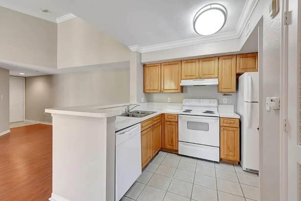 15155 Michelangelo Boulevard, Unit 306 Delray Beach, FL 33446 - Photo 24 of 32 a kitchen with a stove sink and cabinets