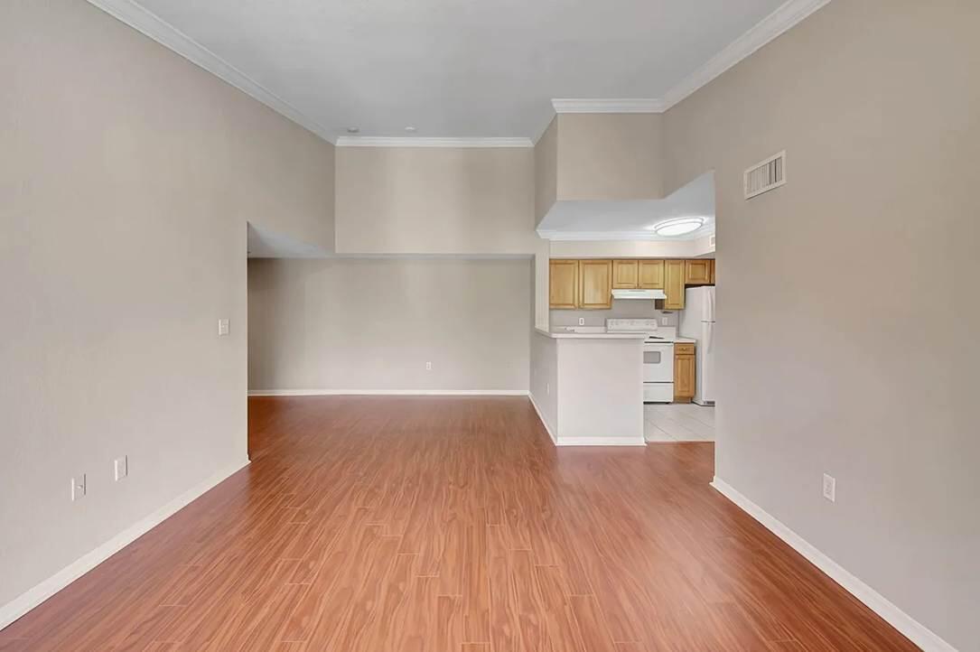 15155 Michelangelo Boulevard, Unit 306 Delray Beach, FL 33446 - Photo 27 of 32 a view of empty room with wooden floor and kitchen