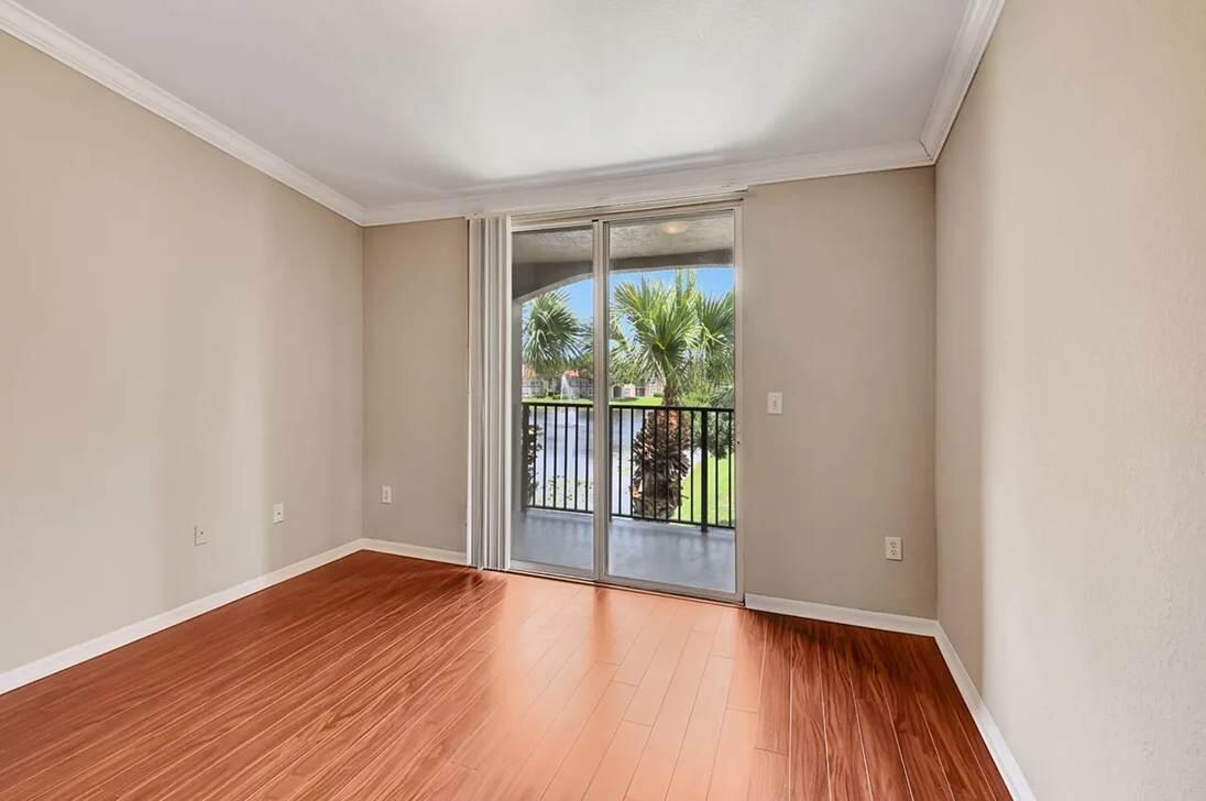 15155 Michelangelo Boulevard, Unit 306 Delray Beach, FL 33446 - Photo 28 of 32 a view of an empty room with wooden floor and a window
