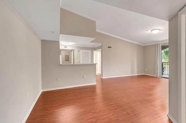 15155 Michelangelo Boulevard, Unit 306 Delray Beach, FL 33446 - Photo 32 of 32 a view of an empty room with wooden floor and a window