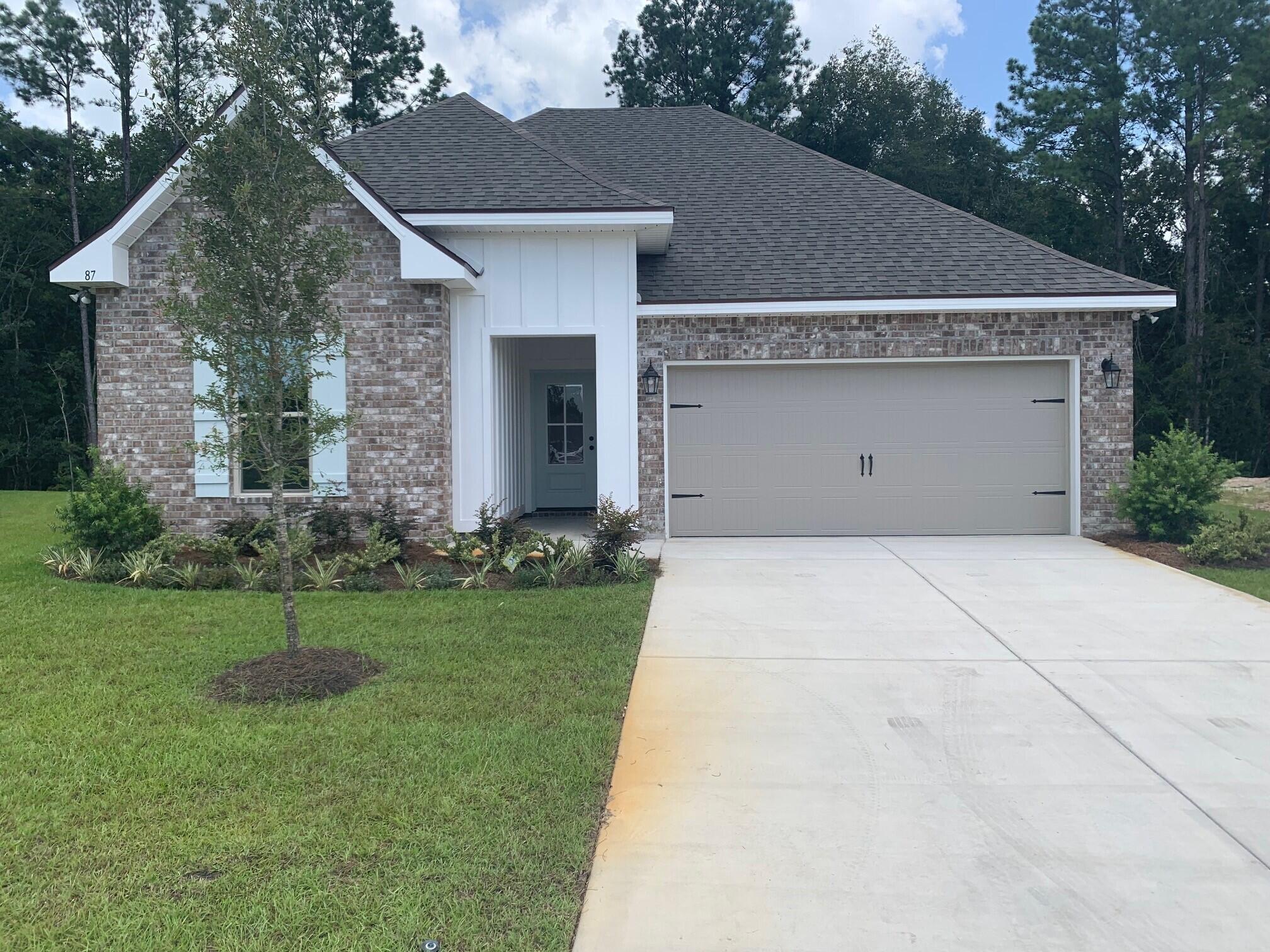 87 Eclipse Loop Freeport, FL 32439 - Photo 1 of 2 a view of a white house next to a yard with big trees