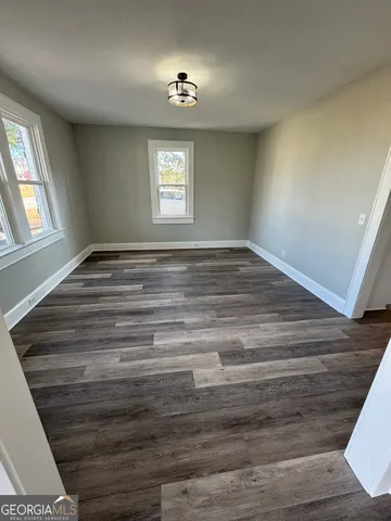 a view of empty room with window and wooden floor