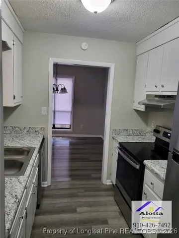 a kitchen with granite countertop a stove and a sink