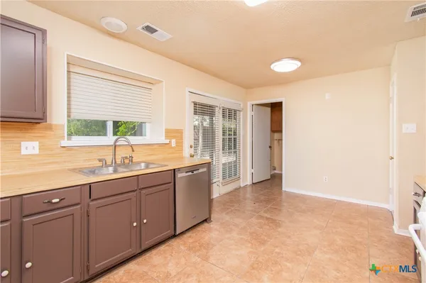 a large kitchen with kitchen island a sink stainless steel appliances and cabinets