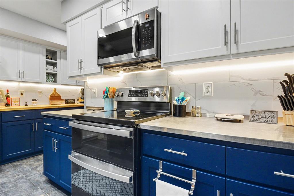 9446 Chimney Corner Dallas, TX 75243 - Photo 14 of 39 a kitchen with stainless steel appliances granite countertop a sink stove and microwave