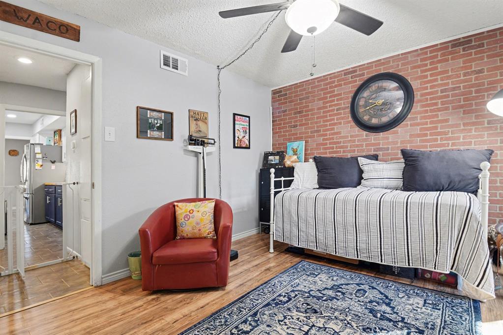 9446 Chimney Corner Dallas, TX 75243 - Photo 16 of 39 a bedroom with bed and a chair