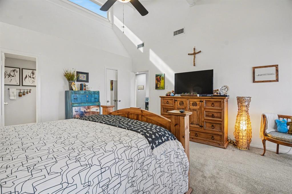 9446 Chimney Corner Dallas, TX 75243 - Photo 23 of 39 a bedroom with a bed and a flat screen tv