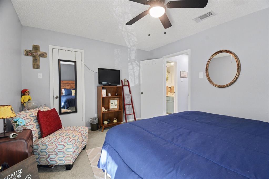 9446 Chimney Corner Dallas, TX 75243 - Photo 27 of 39 a bedroom with a bed couch and a chandelier