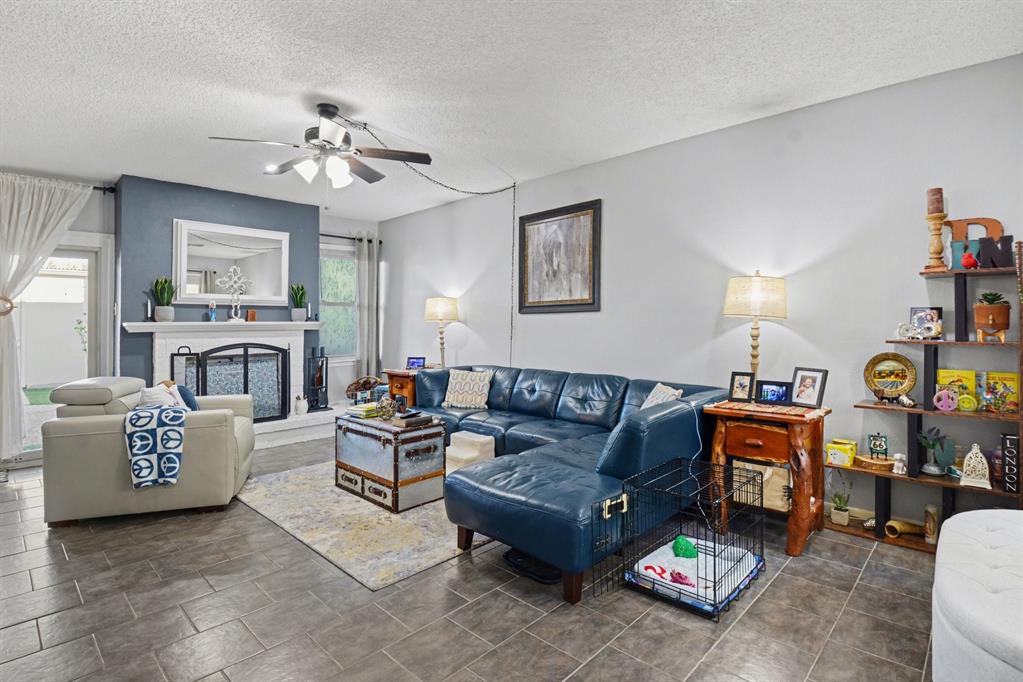 9446 Chimney Corner Dallas, TX 75243 - Photo 4 of 39 a living room with furniture a fireplace and a chandelier