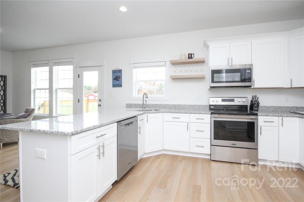 1100 Startown Road Lincolnton, NC 28092 - Photo 13 of 48 a kitchen with granite countertop white cabinets and white appliances