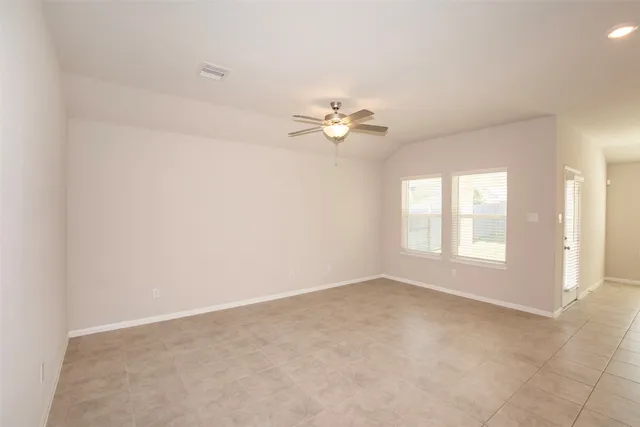 an empty room with a window and a fan