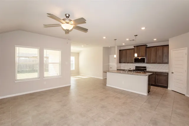 an empty room with a chandelier fan
