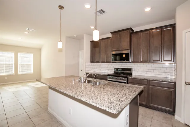 a view of a kitchen with a sink and dishwasher a kitchen island with wooden floor