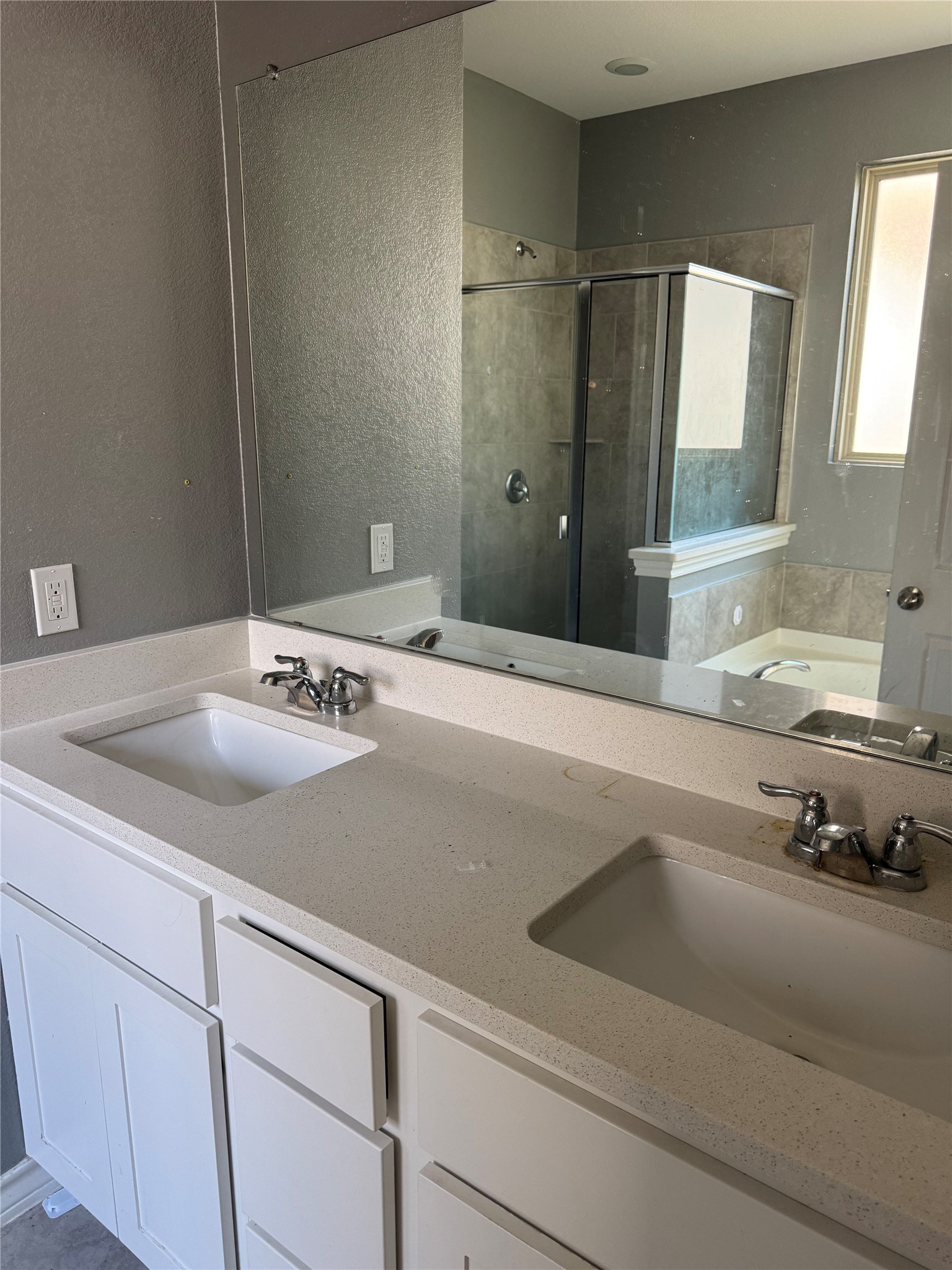 333 Capstone Road Liberty Hill, TX 78642 - Photo 22 of 40 Bathroom featuring a bath, double vanity, a stall shower, and a textured wall
