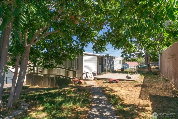 a backyard of a house with barbeque oven and outdoor seating