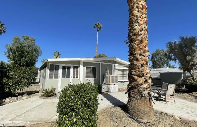 a front view of a house with a yard and potted plants