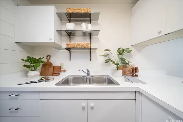 a kitchen with a stove a sink and wooden floor