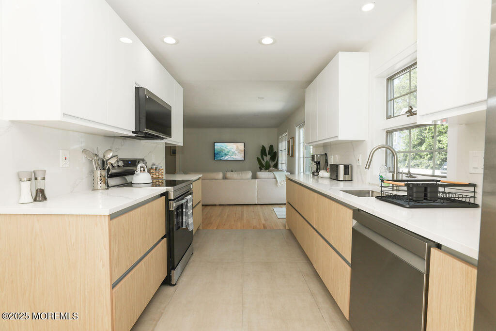 153 Atlantic Avenue Long Branch, NJ 07740 - Photo 21 of 46 a large kitchen with stainless steel appliances lots of counter space sink and a window