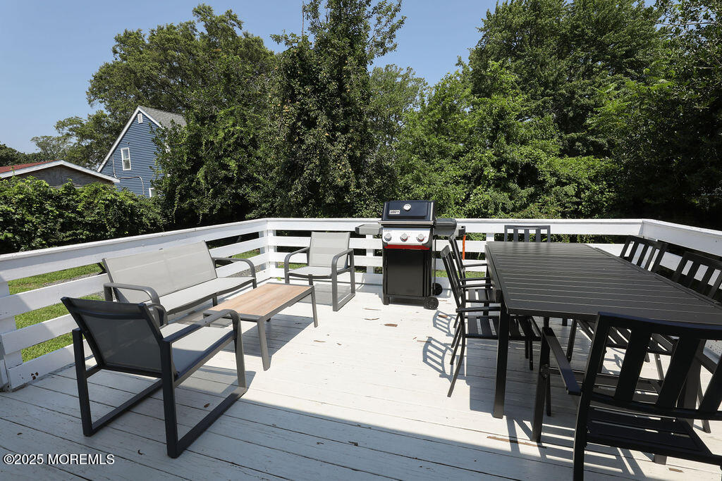 153 Atlantic Avenue Long Branch, NJ 07740 - Photo 42 of 46 a view of a patio with table and chairs with wooden floor and fence
