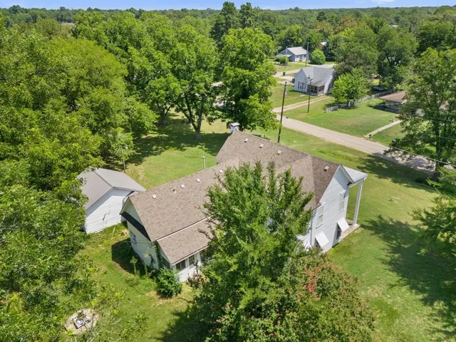 an aerial view of a house with swimming pool and garden view