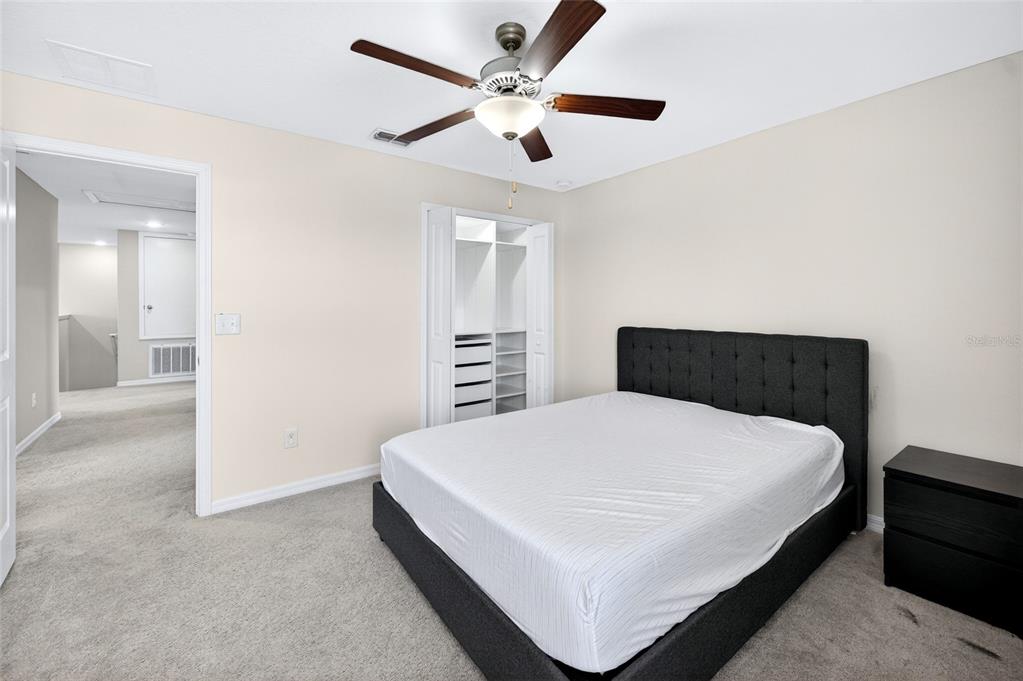 31724 Sun Kettle Loop Wesley Chapel, FL 33545 - Photo 26 of 49 a large bed sitting in a bedroom and a chandelier