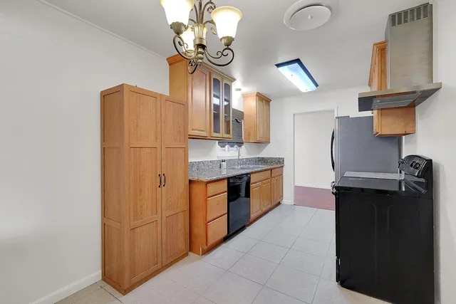 a kitchen with stainless steel appliances granite countertop a refrigerator a sink dishwasher with a dining table and chairs