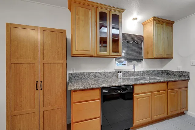 a kitchen with stainless steel appliances granite countertop white cabinets and a refrigerator