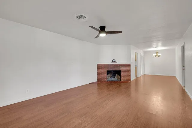a view of empty room with wooden floor and fireplace
