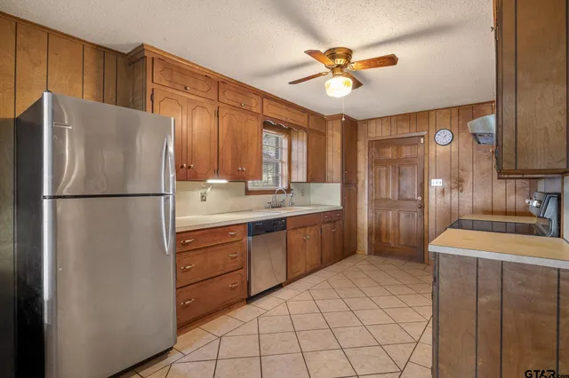 a kitchen with stainless steel appliances a refrigerator sink and cabinets