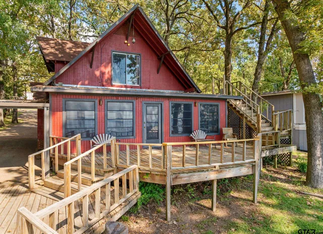 front view of house with a deck and a yard