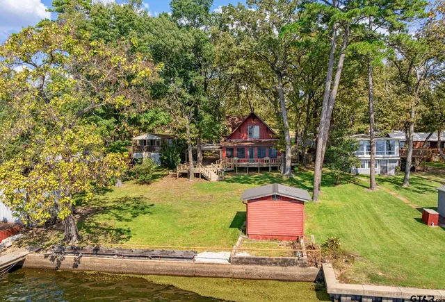 a front view of a house with yard swimming pool and outdoor seating