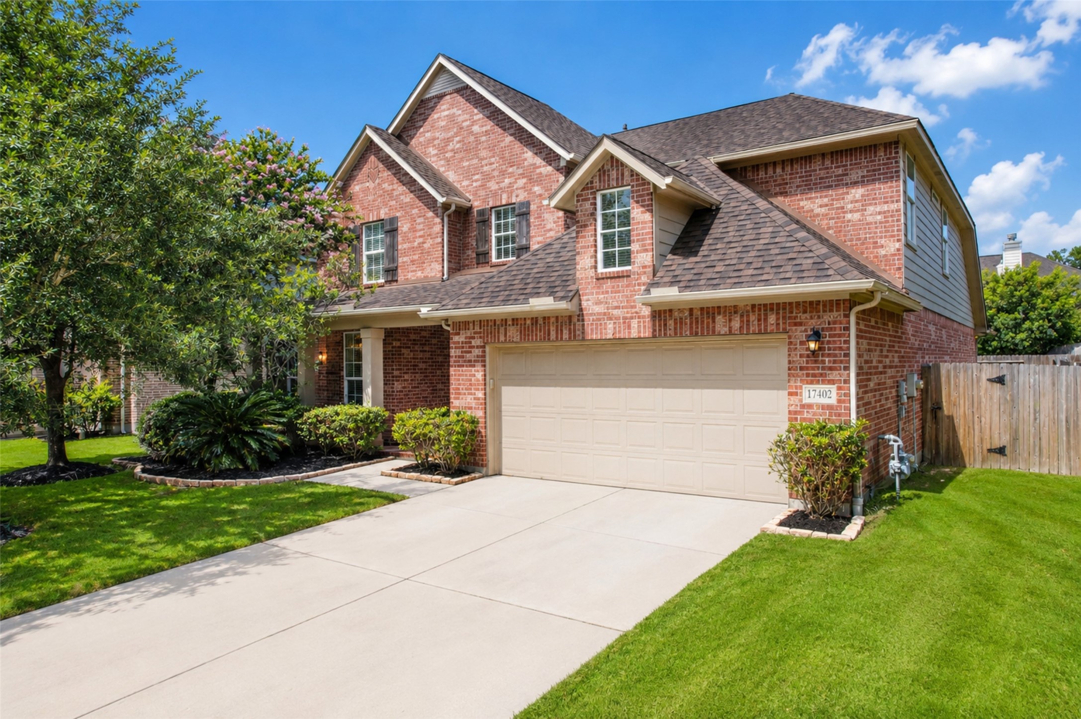 17402 Rainer Valley Lane Humble, TX 77346 - Photo 31 of 33 A charming two-story brick home with a well-maintained lawn, a spacious driveway, and a three-car tandem garage. The front yard features mature trees and landscaped shrubs, creating great curb appeal.