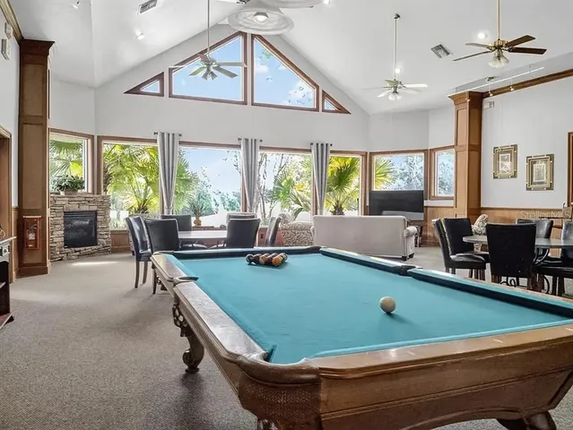 a room with pool table and windows