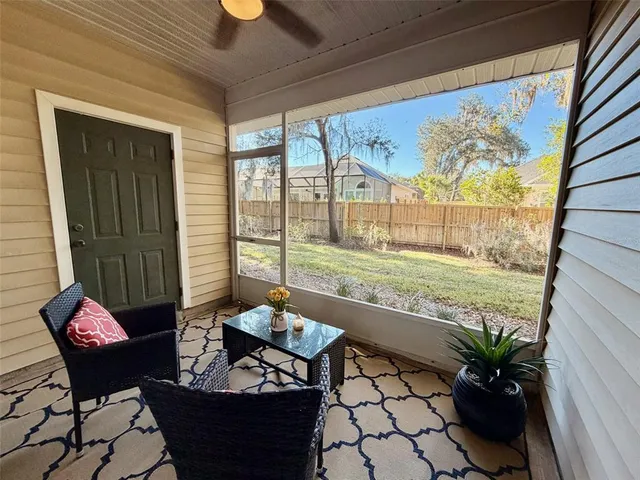 a living room with patio furniture and a potted plant