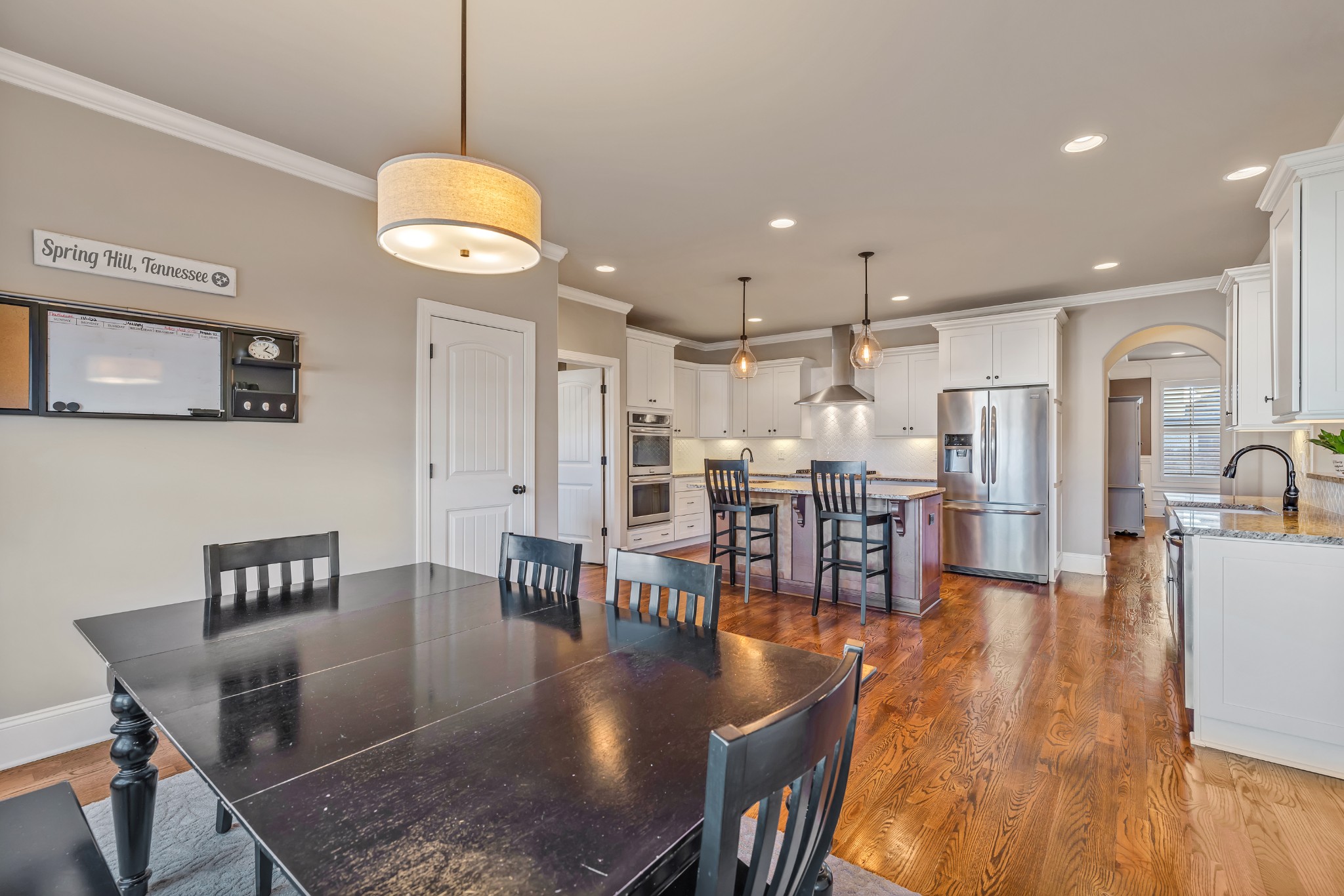 4008 Canberra Drive Spring Hill, TN 37174 - Photo 26 of 63 a view of a dining room and livingroom with furniture wooden floor a rug a fireplace and a chandelier