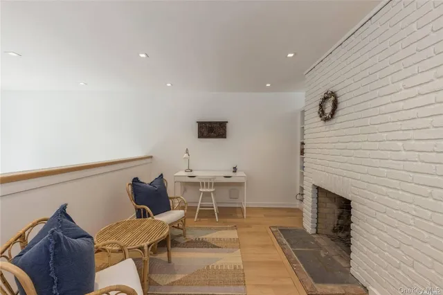 a living room with couches chairs and kitchen view with wooden floor