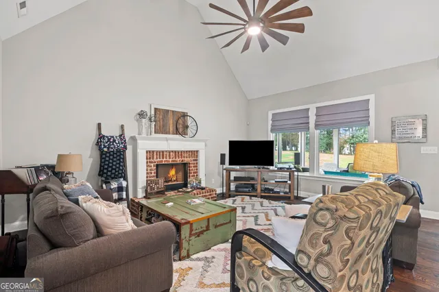 a living room with furniture kitchen view and a large window