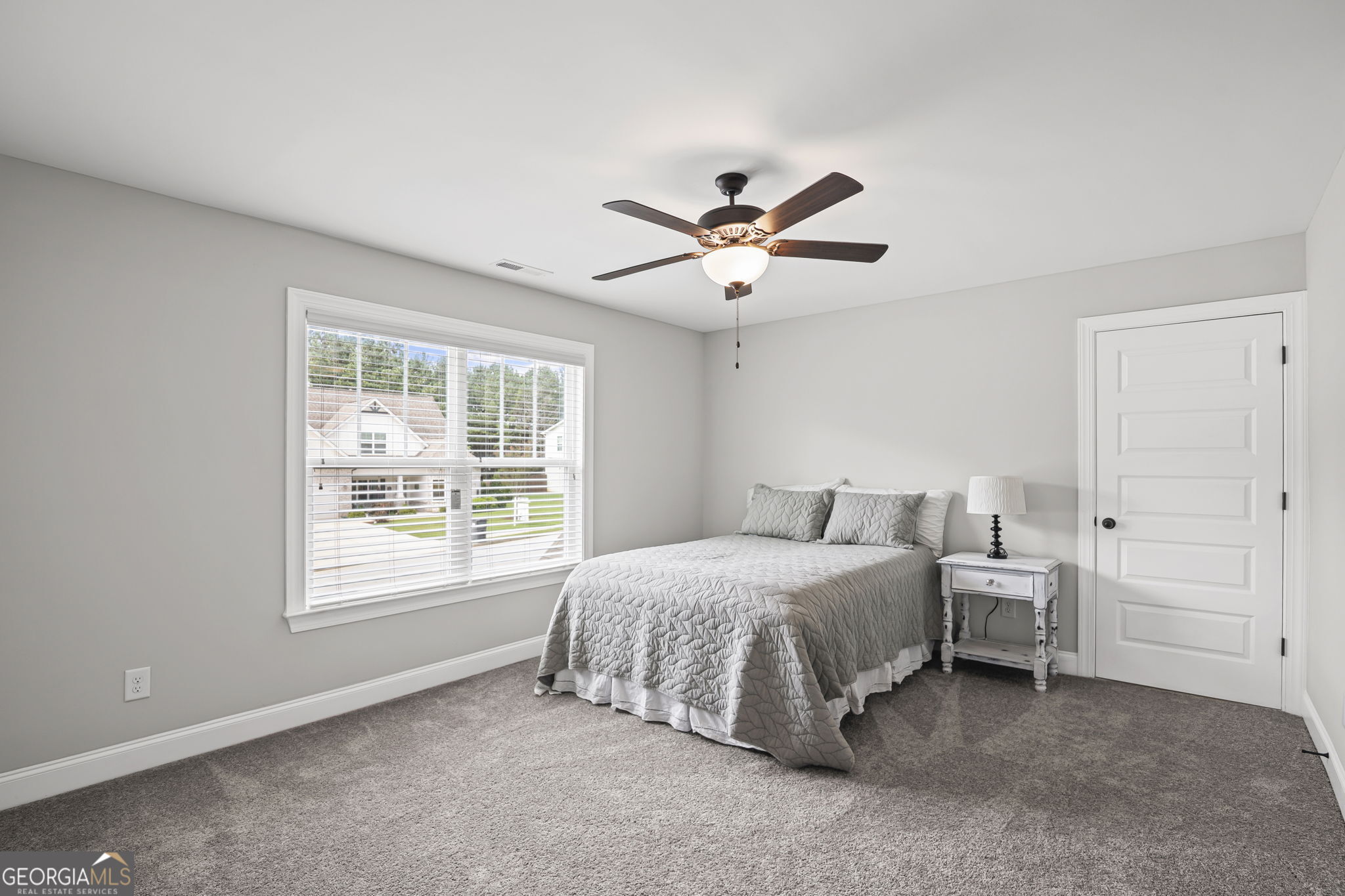 150 Duck Drive Senoia, GA 30276 - Photo 39 of 73 a spacious bedroom with a bed a chandelier and a window