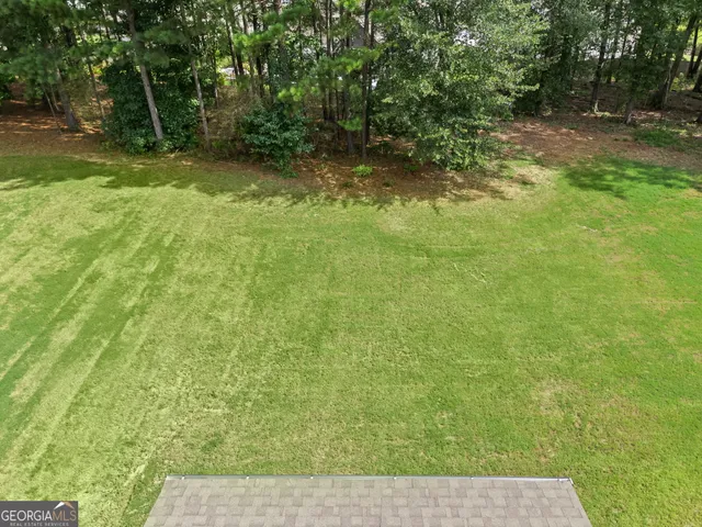 a view of a house with a big yard and potted plants