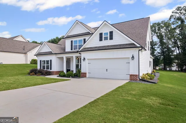 a front view of a house with a garden and yard