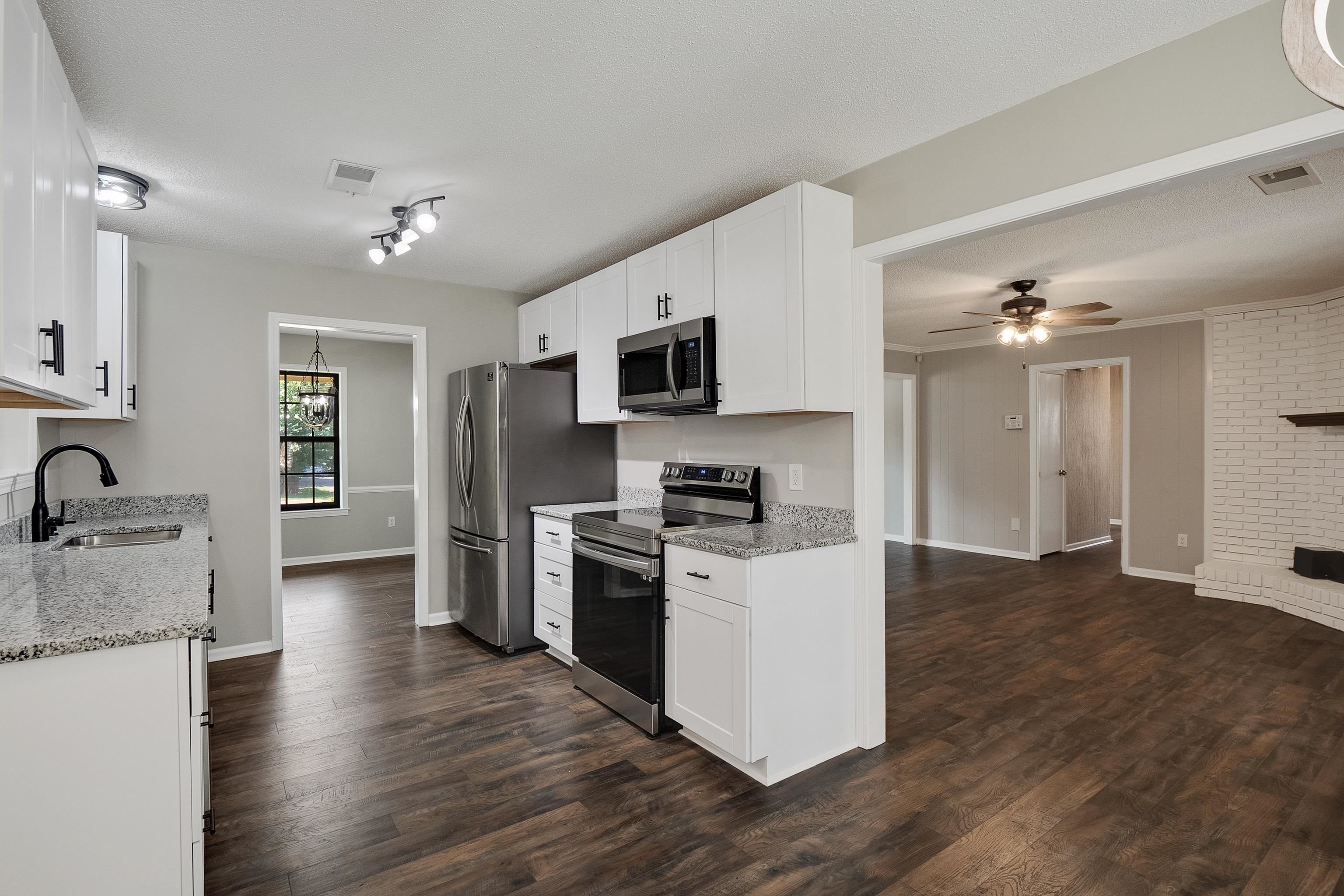 6384 Althorne Road Bartlett, TN 38134 - Photo 3 of 34 a kitchen with granite countertop a stove top oven a refrigerator cabinets and wooden floor