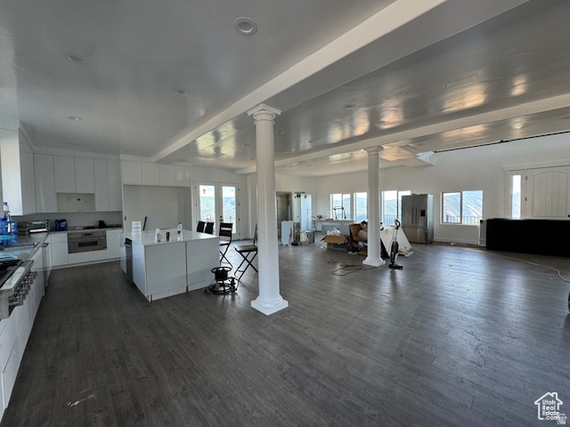 6909 East Spring Drive, Unit 19 Springville, UT 84663 - Photo 7 of 118 Open-concept interior featuring wood-finish flooring, white cabinetry, recessed lighting, and decorative columns