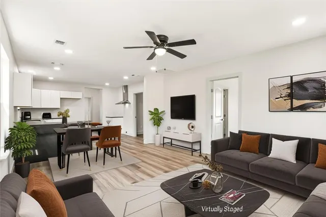 a living room with furniture a flat screen tv and a window