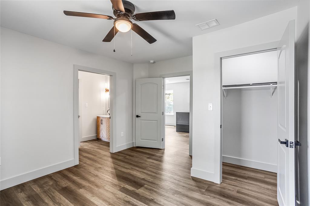 1127 West Morgan Street Denison, TX 75020 - Photo 13 of 23 a view of a room with wooden floor a ceiling fan and a bathroom