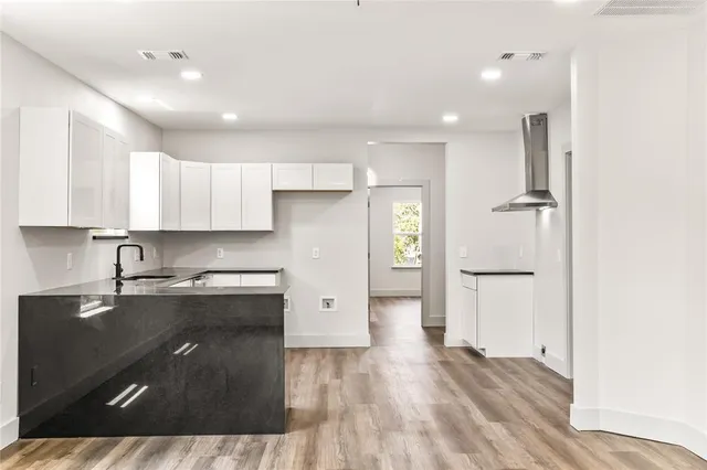 a kitchen with a refrigerator and white cabinets