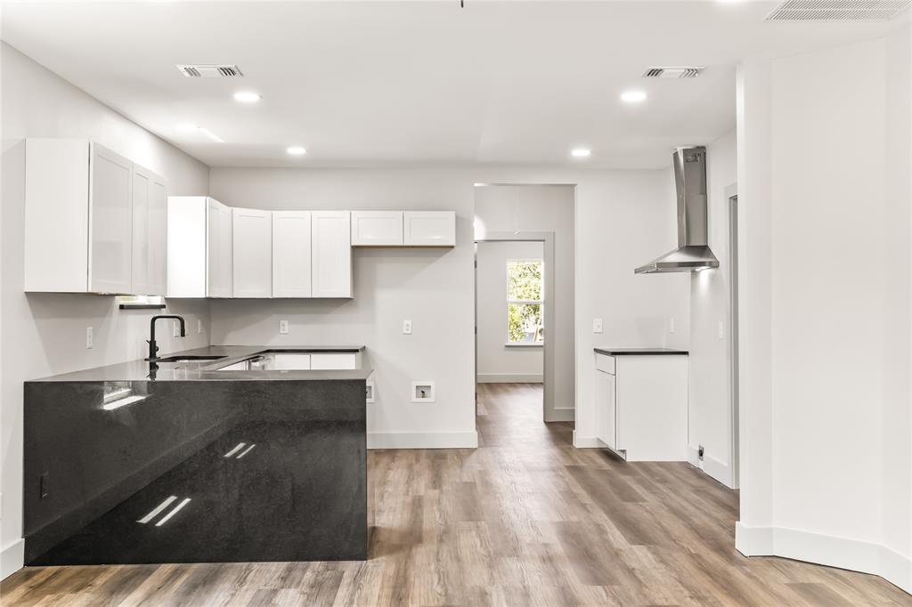 1127 West Morgan Street Denison, TX 75020 - Photo 16 of 23 a kitchen with a refrigerator and white cabinets