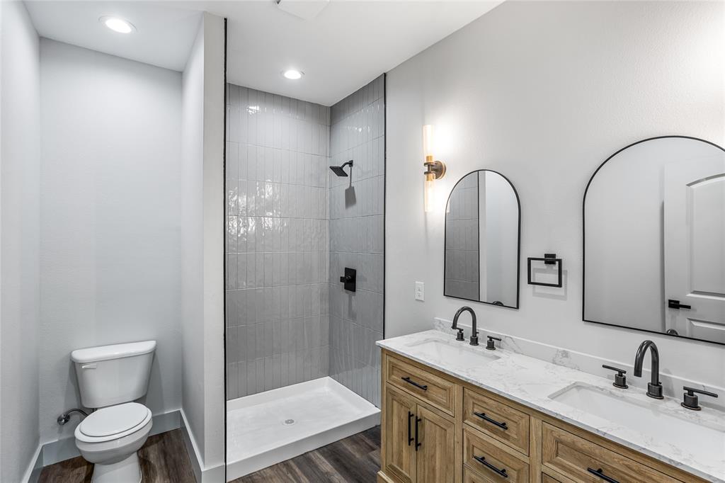 1127 West Morgan Street Denison, TX 75020 - Photo 17 of 23 a bathroom with a double vanity sink mirror and toilet